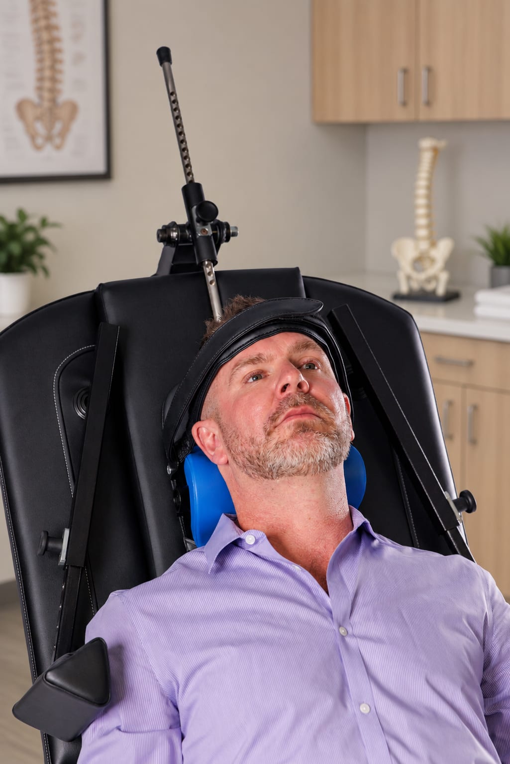 A patient seated and reclined during a treatment visit, with treatment directed at the neck