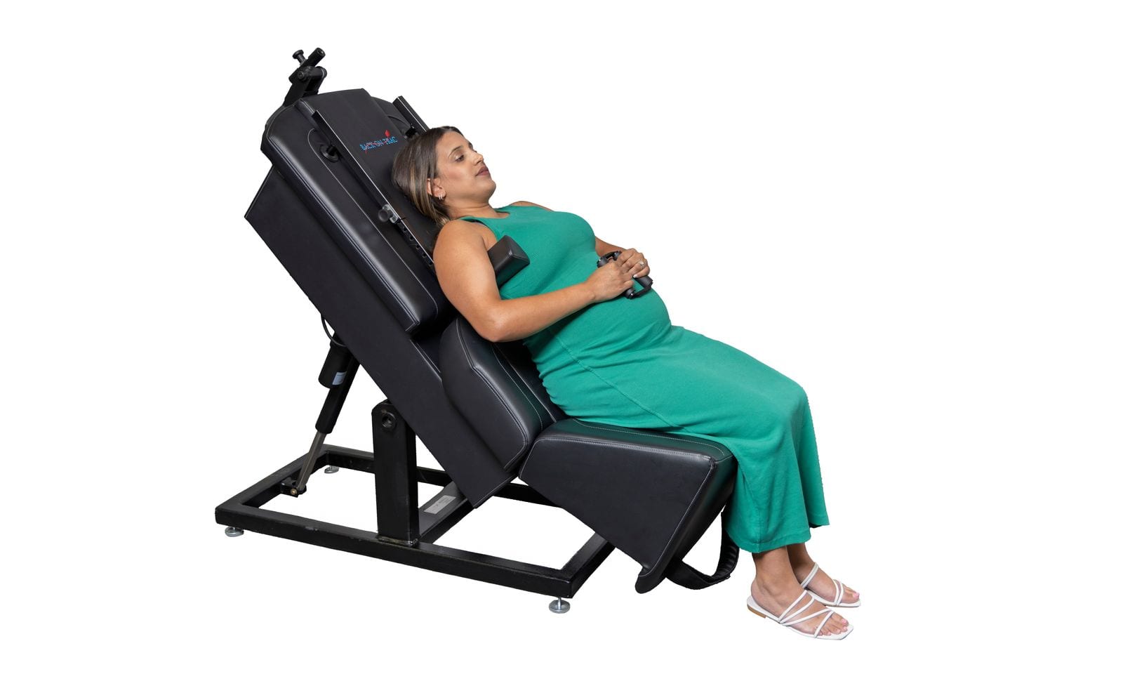 An expecting mother seated and slightly reclined during a prenatal treatment visit, one hand resting on her belly