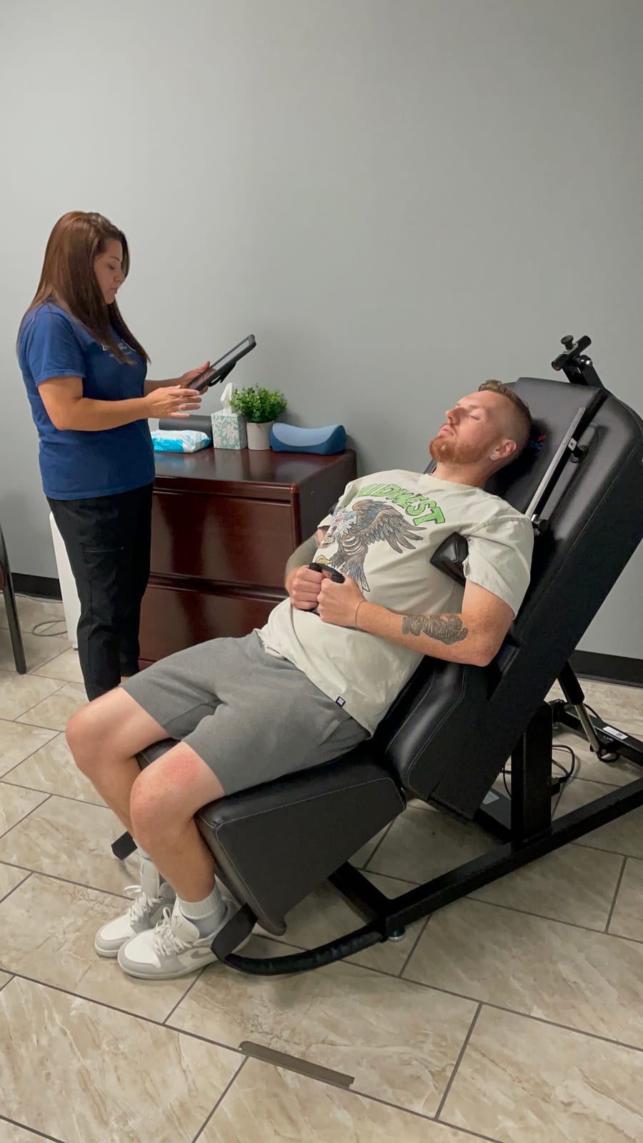 A clinic team member recording a patient's response during a treatment visit